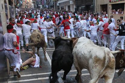 Una joven cae al suelo mientras pasan los toros de la ganadería Fuente Ymbro.