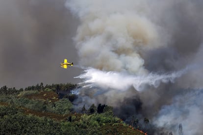Un avión cisterna suelta agua sobre una zona en llamas, en Santa Eulalia (Portugal).