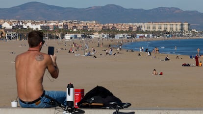 Una persona toma una imagen de la playa de la Malvarrosa en una imagen de archivo.