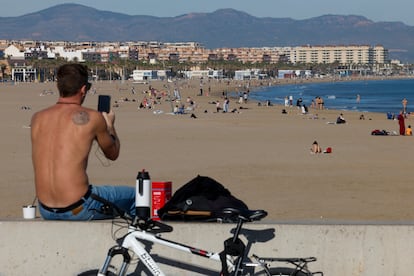 Una persona toma el lunes una imagen de la playa de la Malvarrosa en Valencia, que batió su récord de temperatura máxima para un mes de diciembre.
