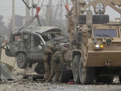 Soldados de EE UU retiran un veh&iacute;culo afectado por la explosi&oacute;n en Kabul. 