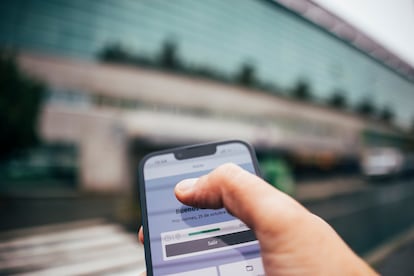 Un trabajador utiliza una app de control de fichaje frente a un edificio de oficinas en Santiago de Compostela (Galicia).