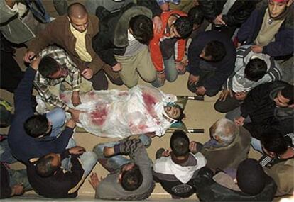 Unos palestinos rezan en una mezquita de Jenín ante el cadáver de unjoven muerto cuando iba a ser arrestado.