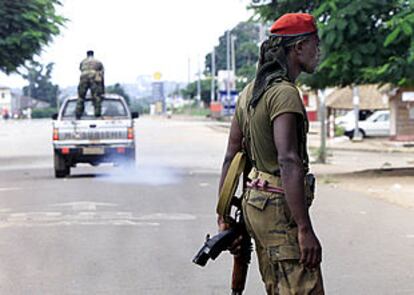 Un soldado rebelde camina por las calles de Bouaké frente a un camión de las tropas sublevadas. ESCENA