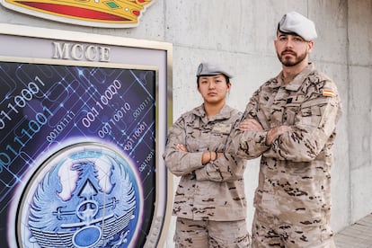 Los alumnos Lucía, suboficial del Ejército del Aire, y Roberto, suboficial del Ejército de Tierra, en la entrada del Mando Conjunto del Ciberespacio, donde por ahora se encuentra la Escuela Militar de Ciberoperaciones (EMCO), en la Base de Retamares, Madrid.