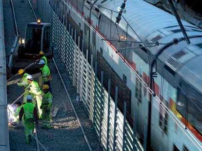 Un tren de Cercanías pasa al lado de las obras del AVE en Bellvitge.