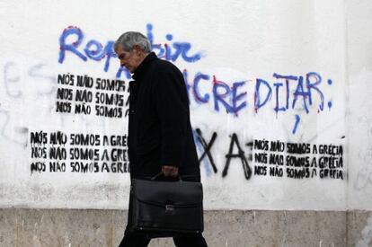Lisboa, 1 de marzo: un hombre camina junto a una pintada que dice: "No somos Grecia"