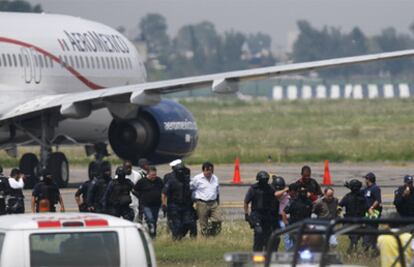 La policía acompaña a los detenidos por el secuestro de avión un avión en México