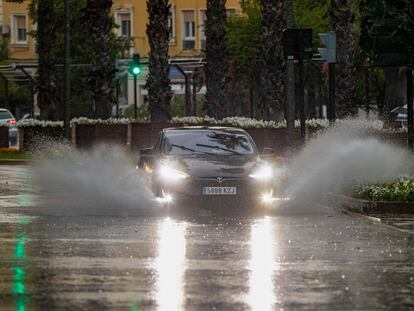 Un coche circula por una calle anegada en la ciudad de Murcia.