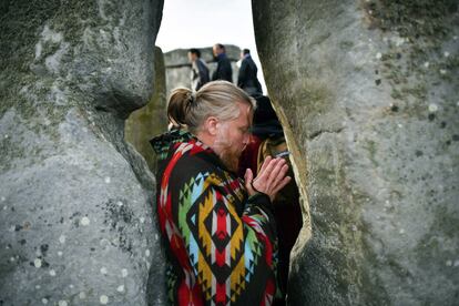 Un hombre reza entre dos piedras del monumento megalítico de Stonehenge durante la celebración del solsticio de verano en Salisbury (Inglaterra). 