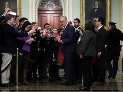 Chuck Schumer, líder da minoria democrata do Senado, cercado por jornalistas.