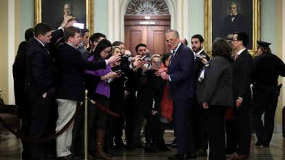 Chuck Schumer, líder da minoria democrata do Senado, cercado por jornalistas.