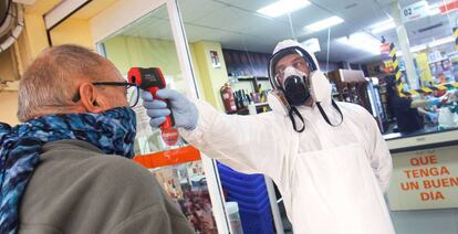 Un empleado de un supermercado de la zona de La Mata de Torrevieja toma la temperatura a sus clientes.