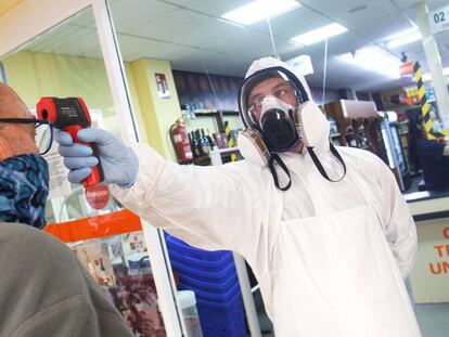 Un empleado de un supermercado de la zona de La Mata de Torrevieja toma la temperatura a sus clientes.