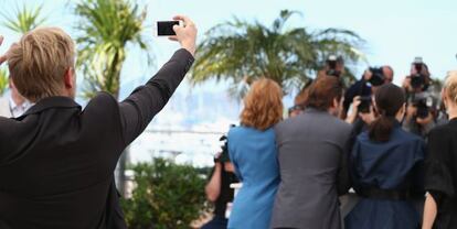 El actor Jeremie Renier se saca un 'selfie' mientras sus compañeros de la película 'Yves Saint Laurent' posan en el 'photocall' del festival de Cannes