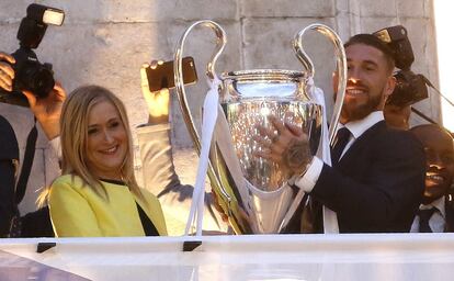 La presidenta de la Comunidad de Madrid, Cristina Cifuentes, y el capitán del Real Madrid, Sergio Ramos, saludan a los seguidores, en la Puerta del Sol.