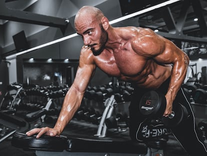 Usuario de un gimnasio haciendo ejercicios de musculación.