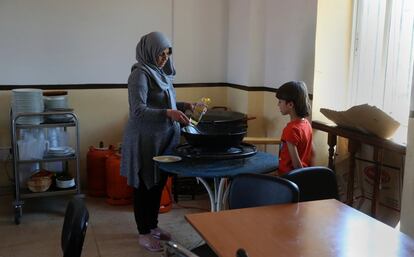 Muna cocina ante la mirada atenta de su hijo Ibrahim.