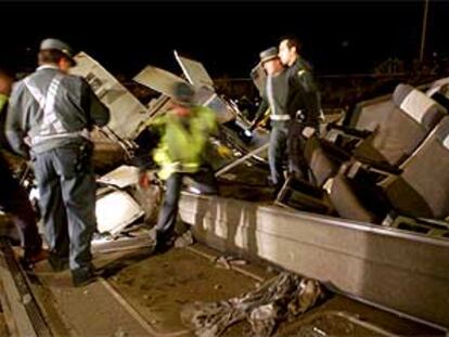 Miembros de la Guardia Civil inspeccionan los restos del Talgo descarrilado.