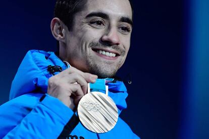 El patinador muestra su medalla de bronce.