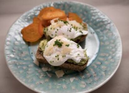 Eggs Benedict served over avocado toast at Panela & Co in Madrid.