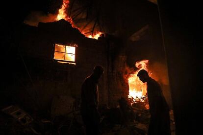 Varias personas intentan apagar el fuego de un edificio en Duma (Siria), el 23 de marzo de 2018.
