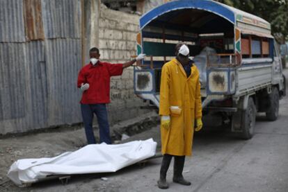 Miembros del equipo sanitario encargado de recoger cadáveres sacan varios cuerpos de un hospital de Puerto Príncipe, el pasado domingo.