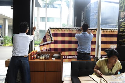 Camareros de un un restaurante de Jakarta, Indonesia, colocan una cortina para evitar que no se vea a los comensales que no observan el ramadán desde la calle. Indonesia es el país con mayor número de musulmanes.