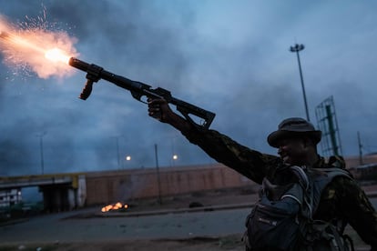 TOPSHOT - A Kenyan Police officer fires teargas towards supporters of Kenya's Azimio La Umoja Party (One Kenya Coalition Party) presidential candidate Raila Odinga, during a demonstration in Kisumu on August 15, 2022, after William Ruto was announced as Kenya's president-elect. - The head of Kenya's election body on August 15, 2022 declared Deputy President William Ruto the winner of the country's close-fought presidential election, despite several commissioners rejecting the results. Independent Electoral and Boundaries Commission chairman Wafula Chebukati said Ruto had won almost 7.18 million votes (50.49 percent) against 6.94 million (48.85 percent) for his rival Raila Odinga in the August 9 vote. (Photo by Yasuyoshi CHIBA / AFP)