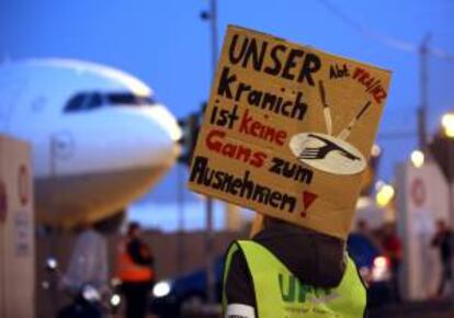 Un empleado de la aerolínea alemana Lufthansa protesta con un letrero que dice: "nuestra grulla (símbolo de la compañía) no es un ganso" hoy en Fráncfort (Alemania).