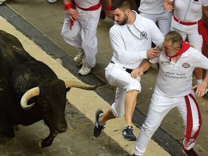 Dos corredores, pendientes de uno de los toros en el quinto encierro.