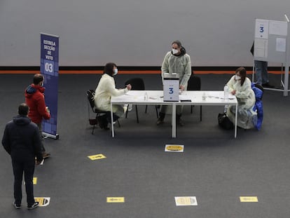 Votantes aguardan este domingo ante la mesa de un colegio electoral en Lisboa para depositar su papeleta.