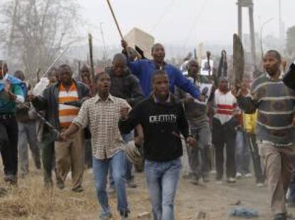 En la imagen, miles de mineros de la la mina sudafricana de platino de Lonmin en huelga a las puertas de la mina de Karee exigiendo un aumneto de sueldo en Marikana (Sudáfrica). EFE/Archivo