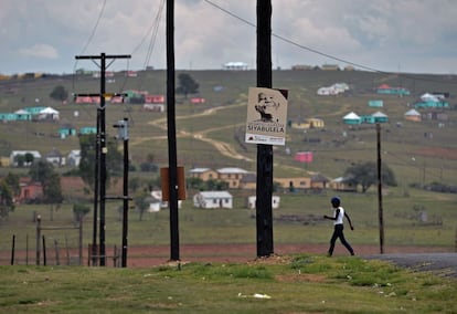 Un niño camina junto a un cartel con la imagen de Nelson Mandela en Qunu (Sudáfrica), cerca de la granja donde el líder sudafricano paso su infancia.