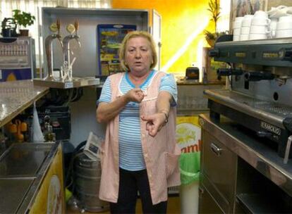 Remedios Morán, dueña del bar-restaurante Remi de Pulianas (Granada), escenifica el último de los 12 atracos que ha sufrido en dos años.