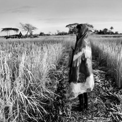 Una niña bijagó junto a un campo de arroz vestida con el chal tradicional. Bijagós, Guinea-Bissau, 2013