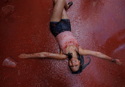 An attendee in a pool of tomato at the Tomatina 2018.