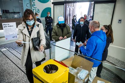 Reparto de mascarillas en la entrada de un colegio electoral en Madrid. La Comunidad ha puesto a disposición de los electores casi cinco millones de mascarillas quirúrgicas, además de 124.000 FFP2 para los miembros de las mesas, 55.000 litros de gel hidroalcohólico, dos millones de guantes y 45.000 pantallas de protección facial.