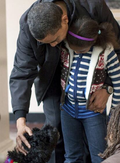 Obama, abrazado a su hija pequeña, Sasha, acaricia a <i>Bo</i> en presencia de su otra hija, Malia.