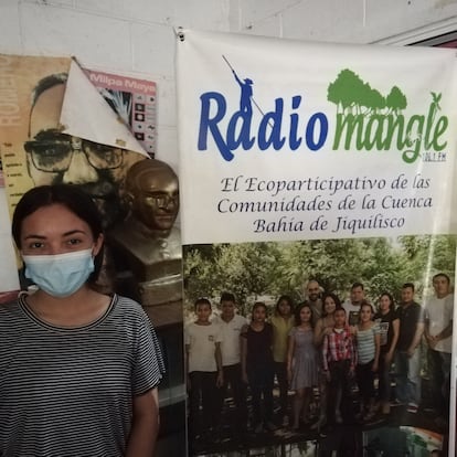 Wendy Hernández explica frente a un busto del Padre Romero que la radio sirve como instrumento en la comunidad para denunciar crímenes ambientales, como el robo de tierras.