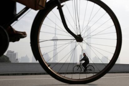 Dos personas montan en bicicleta en el distrito financiero Pudong de Shanghái (China).