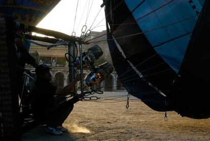 El otro técnico llena de gas propano la envoltura del globo para elevarlo.