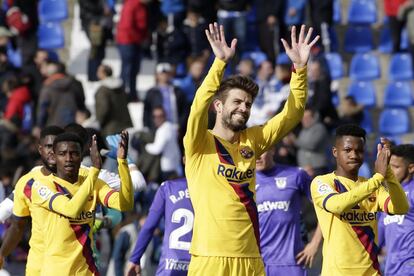 El defensa del Barcelona Gerard Piqué (centro) saluda a los seguidores tras el partido.