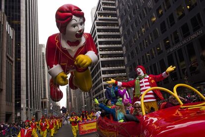 Ronald McDonald saluda al público mientras le precede un globo con su imagen durante el desfile.