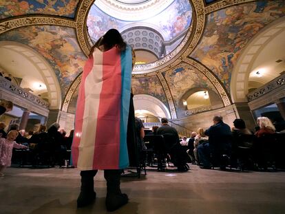 Glenda Starke wears a transgender flag as a counter protest during a rally in favor of a ban on gender-affirming health care legislation