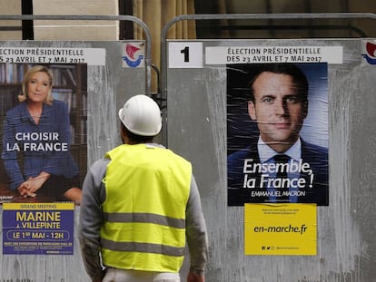 Operário observa cartazes dos candidatos do segundo turno na França.
