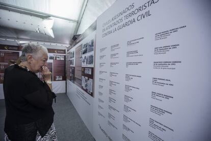 Una mujer lee una lista de v&iacute;ctimas del terrorismo en una exposici&oacute;n que ha inaugurado este octubre la Guardia Civil en M&aacute;laga.