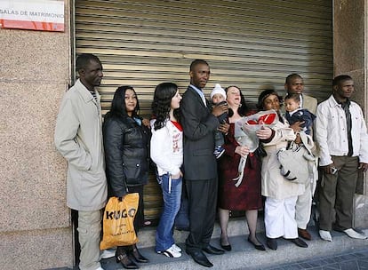 Un grupo de personas espera en el Registro Civil para celebrar una boda.