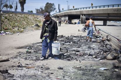 Una persona del canal camina sobre las cenizas de un ñongo. La gente asegura que la policía de Tijuana prende fuego a sus casas construidas con desperdicios de plástico y cartón