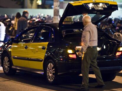 Un taxista carga maletas en la Estación de Sants de Barcelona.